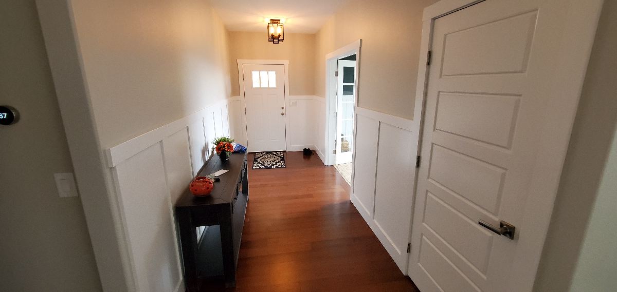 Painted hallway with white wainscoting and doors