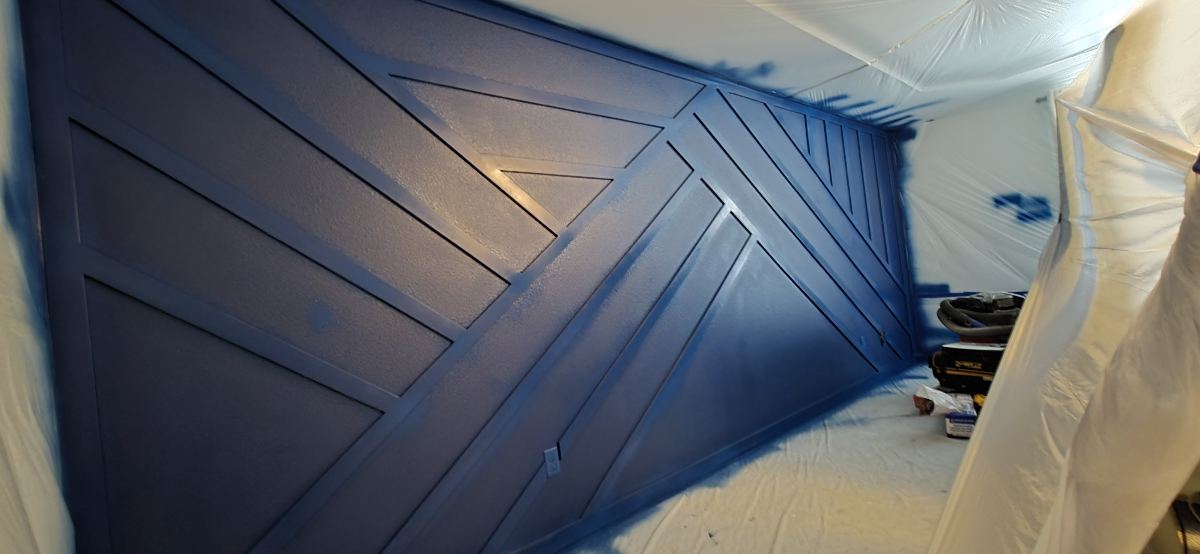 Dark geometric wood feature wall during finishing