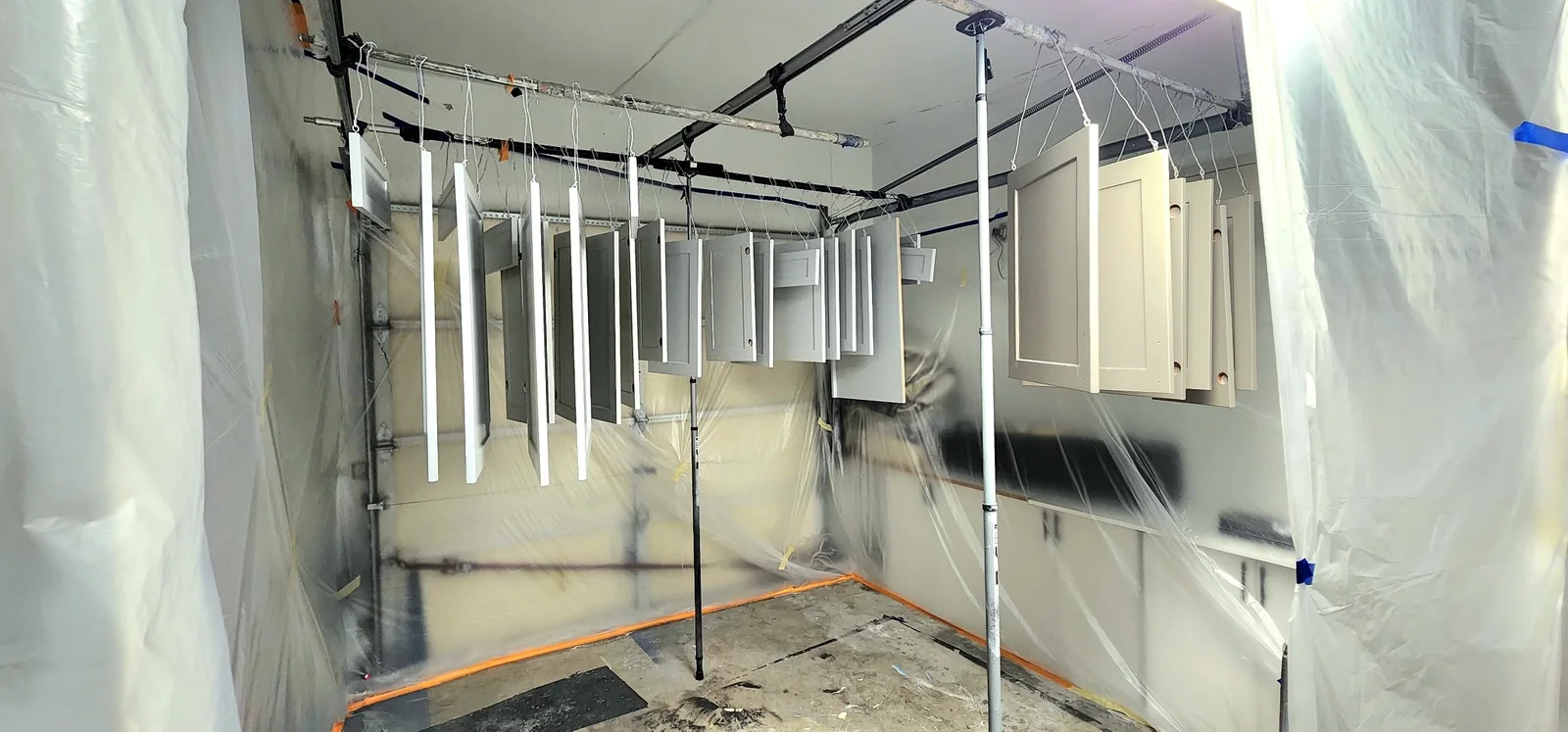 Cabinet doors suspended in a protected spray area